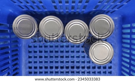 Canned drink in the blue plastic basket from supermarket 