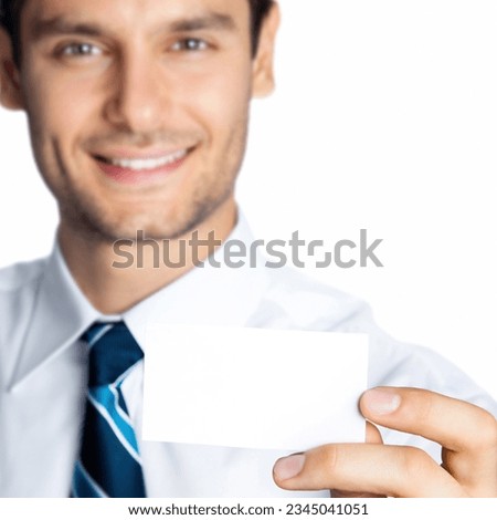 Happy smiling young business man showing blank business, plastic, credit card or signboard, isolated over white background