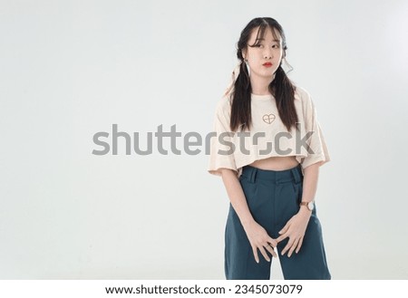 Portrait isolated cutout studio shot of Asian young cute female teenage fashion model with pigtails braids hairstyle in casual trendy wear standind posing look at camera on white background