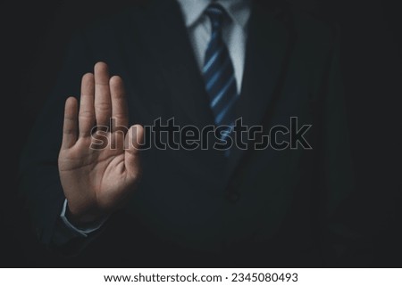 male hand showing stop gesture Concept of stop violence. Warning, prohibition, denial. On dark background. Royalty-Free Stock Photo #2345080493