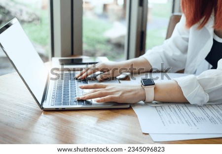 Young asian female or freelancer in casual clothes working with laptop and documents of business contract and work agreements at desk