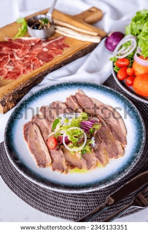 Smoked Duck Breast Thinly Sized with vegetable on top in Plate 
