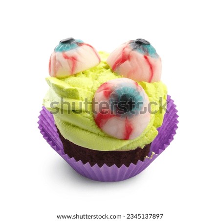 Delicious Halloween cupcake with eyes on white background