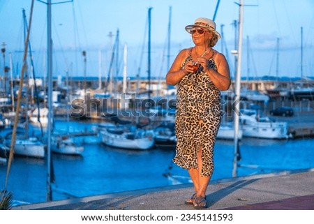 Elegant Mature Woman Enjoying a Cocktail by Yachts in the Marina