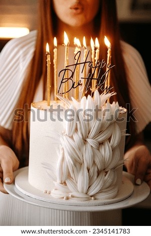 girl blowing out candles on her happy birthday cake
