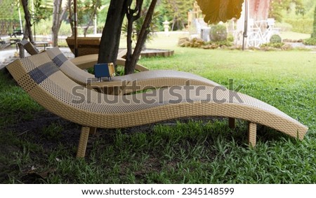 Artificial rattan bed on the lawn, chilling coffee shop corner It is a bed that is designed to be suitable for lounging by the pool, seaside, or outside seating area. soft and selective focus.        