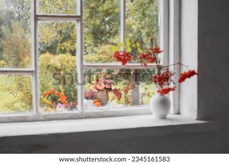 rowan berries in white vase on old white windowsill