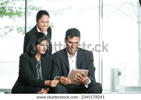 Happy Indian Business man and woman looking at a digital tablet. Royalty-Free Stock Photo #2345178241