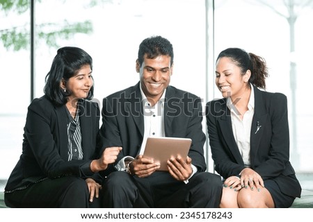 Happy Indian Business man and woman looking at a digital tablet. Royalty-Free Stock Photo #2345178243