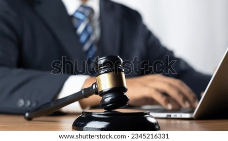 Justice, Law, Attorney and Court judge concept. Man judge hand holding gavel to bang on sounding block in the court room. Professional lawyer considering with contract papers in courtroom. Royalty-Free Stock Photo #2345216331