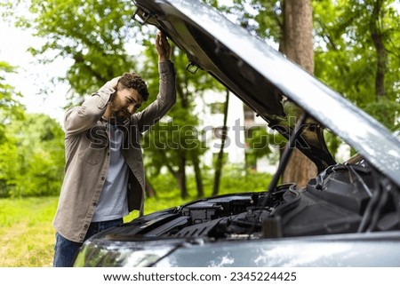 Man checking his broke down car. Royalty-Free Stock Photo #2345224425