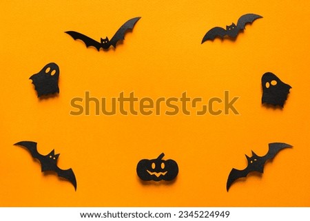 Halloween decorations, bats, pumpkin and ghosts on orange background. Halloween party greeting card mockup with copy space. Happy halloween holiday concept. Flat lay, top view
