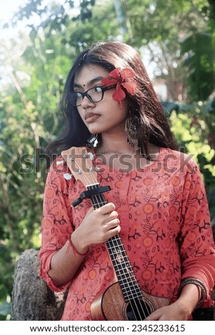 South asian young fashionable girl with ukulele 