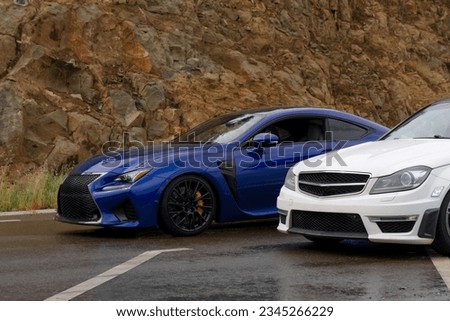 Modern blue and white racing cars on a mountain road. Headlights, optics, detailed photo. Wheels, rims. Drift, street racing. Test Drive. Sports coupe. Two cars.  Royalty-Free Stock Photo #2345266229