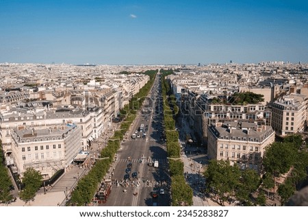 High-angle view of Paris cityscape from the Eiffel Tower on a sunny day with blue sky.