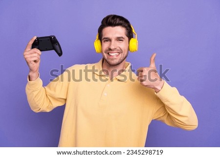 Photo of cool confident guy wear yellow shirt earphones thumb up recommend playstation game isolated violet color background
