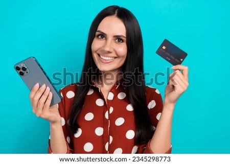 Photo of young positive promoter banker lady brunette hair hold plastic debit new card buy wireless phone isolated on blue color background
