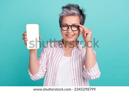 Photo of cheerful senior woman touch glasses intelligent person hold phone display information qr code isolated on blue color background Royalty-Free Stock Photo #2345298799
