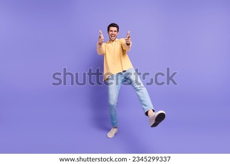 Full length photo of confident funky man dressed yellow shirt pointing two fingers you isolated purple color background