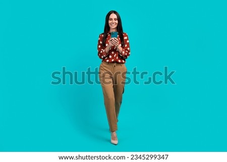 Full size photo of classy positive pretty girl walk use smart phone write blog post isolated on teal color background