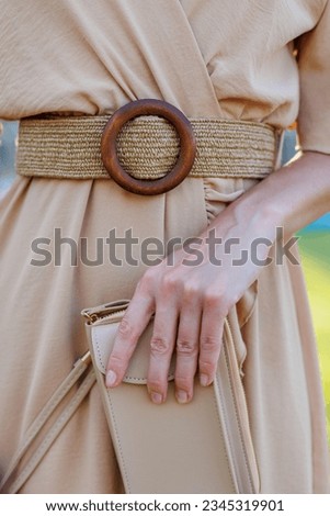 stylish girl in an evening dress holds a small bag in her hands. stylish accessories. fashion and style concept.
