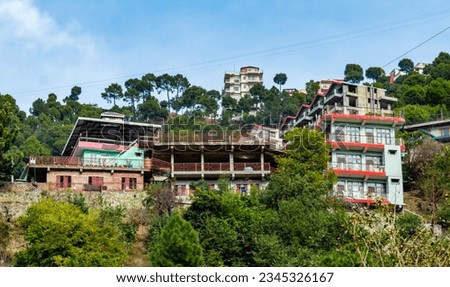 photography of buildings situated on mountain along with trees under the cloudy sky.