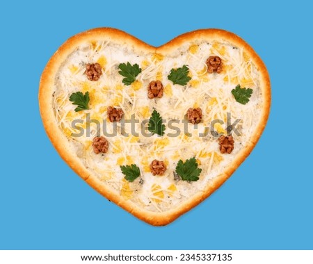 appetizing pizza in the shape of a heart with 4 cheeses (mozzarella, dor blue, parmesan and gouda) on a blue background, studio shot