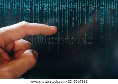 index finger pointing at digital screen, binary code
