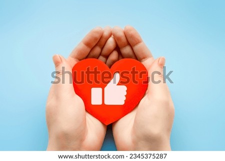 gesture like thumbs up concept. Image of male hand on paper heart. girl holding paper heart with like gesture, male hand thumbs up. creative success concept