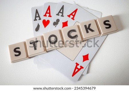 Four aces and letters spelling stocks.