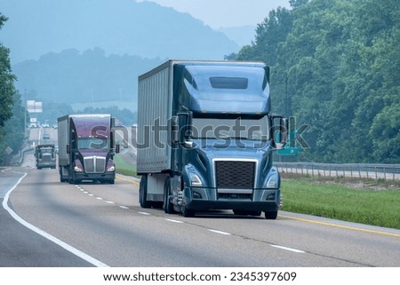 Horizontal shot of interstate truck traffic in Tennessee Smoky Mountain fog. Royalty-Free Stock Photo #2345397609