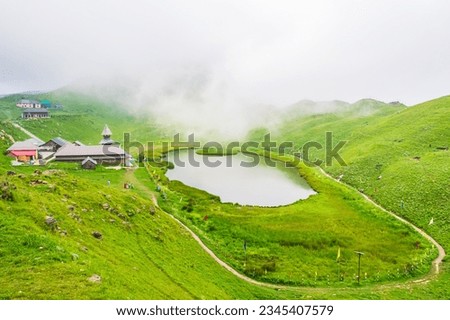 View at Prashar Lake located at a height of 2730 m above sea level with a three storied pagoda-like temple of sage Prashar near Mandi, Himachal Pradesh, India. The lake has a floating island in it. Royalty-Free Stock Photo #2345407579