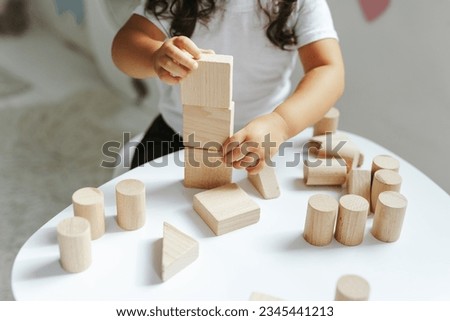 children play with wooden toys in the children's room Royalty-Free Stock Photo #2345441213