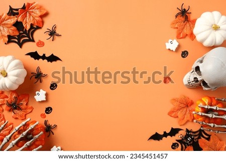 Flat lay composition with Halloween decorations, pumpkins, bats, ghosts, spiders, maple leaves on orange background. Halloween banner design, greeting card template. Flat lay, top view.