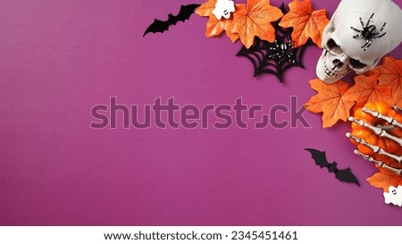 Halloween scary decorations on purple background. Halloween banner template with skull, spiders webs, bats, skeleton hands,  ghosts, maple leaves. Flat lay, top view.