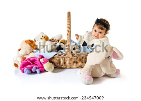 Cute baby inside basket with stuffed animals 