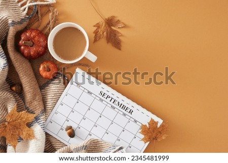 Get cozy with autumn decor in september. Top view photo of calendar, cocoa mug, warm blanket, pumpkins, acorns, dry maple leaves on pastel brown background with empty space for promo or text