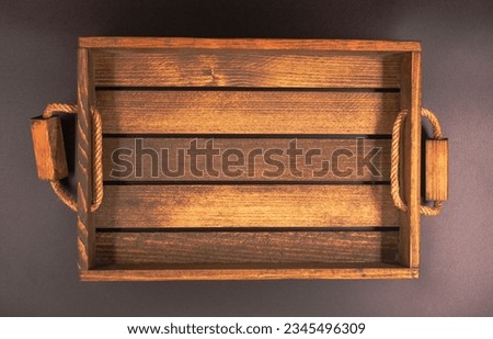 Top view photo of a deep wooden serving tray with handles.