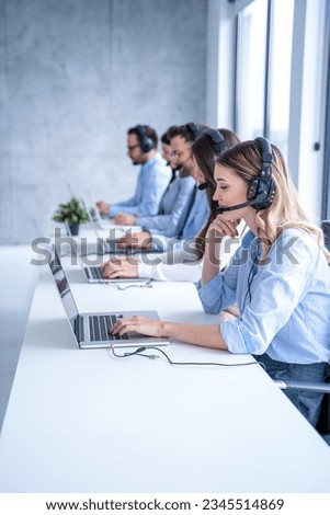Smiling blond haired customer support agent woman listening attentively to the client's inquiries, demonstrating her dedication to providing top-notch service. Royalty-Free Stock Photo #2345514869