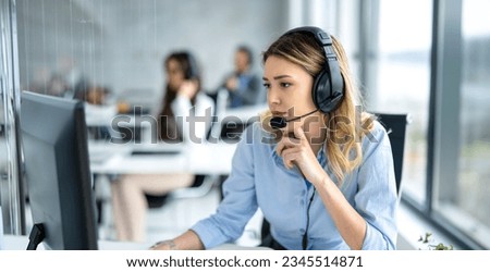 Pensive female helpdesk service agent working on computer at call center. Royalty-Free Stock Photo #2345514871