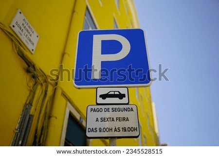 A closeup shot of a traffic parking sign with a blue sky in the background