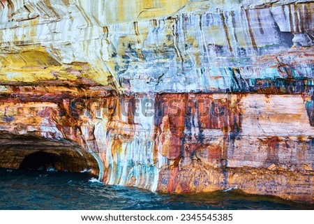 White and yellow streaks in stone plus iron mineral deposits with Pictured Rocks cliff wall
