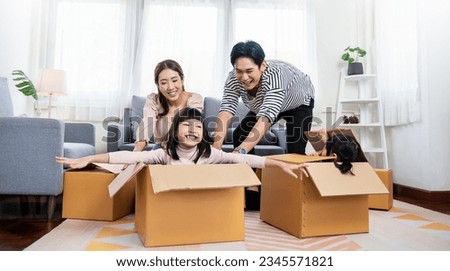 Asian family father mother daughter girl packing cardboard box relocation moving to new house, online marketing e-commerce unpacking stuff belongings home delivery. Lifestyle asian family together  Royalty-Free Stock Photo #2345571821