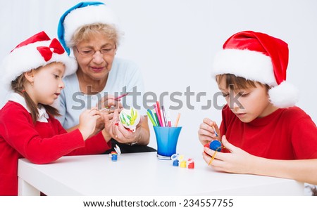children with grandmother in santa hats preparing to Christmas