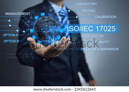 Businessman holding world of ISO IEC 17025 Laboratory Management System, Testing and Calibration Laboratory Quality Assurance certified body. To approve result or certificates to industry companies. Royalty-Free Stock Photo #2345612643