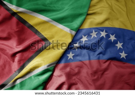 big waving realistic national colorful flag of guyana and national flag of venezuela . macro Royalty-Free Stock Photo #2345616431