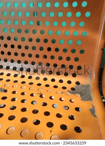 perforated pattern on orange health installation waiting chairs with selective exposure