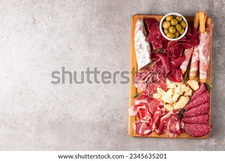 Charcuterie board. Antipasti appetizers of meat and cheese platter with salami, prosciutto crudo or jamon and olives Royalty-Free Stock Photo #2345635201