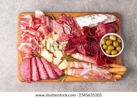 Charcuterie board. Antipasti appetizers of meat and cheese platter with salami, prosciutto crudo or jamon and olives Royalty-Free Stock Photo #2345635203