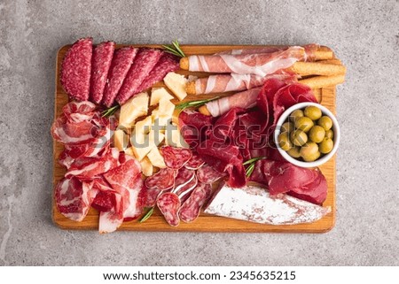 Charcuterie board. Antipasti appetizers of meat and cheese platter with salami, prosciutto crudo or jamon and olives Royalty-Free Stock Photo #2345635215